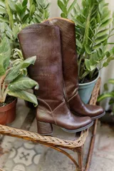 Bota de caña alta color marrón con textura símil reptil, taco cuadrado forrado en cuero y cierre lateral.