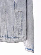 Campera de jean celeste con efecto lavado, corte recto, cuello clásico, cierre frontal con botones metálicos, bolsillos con solapa en el pecho y bolsillos laterales.