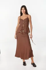 Falda larga color beige de corte sirena confeccionada en lino italiano, con pretina interior elástica y diseño fluido.