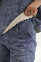 Top sin mangas de corte recto y holgado, confeccionado en tejido de lino con textura jaspeada en tono azul. Presenta cuello redondo y un diseño minimalista ideal para climas cálidos.