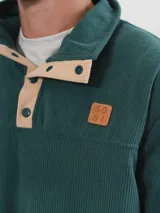 Buzo de pana color beige con cuello polo abotonado y bolsillo en el pecho.