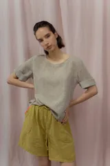 Short blanco de calce relajado con cintura elástica y lazo regulable. Presenta bolsillos amplios con ribete interior de color naranja neón.