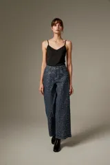 Pantalón jean ancho de tiro medio, completamente revestido con lentejuelas azul oscuro, de corte recto y cinco bolsillos.