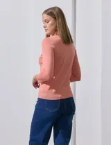 Cardigan blanco de tejido fino con abertura central y botones.