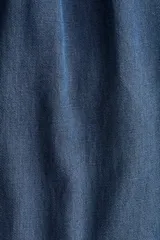 Pantalón de denim suave color azul, de corte holgado estilo globo con piernas abombadas, cintura elastizada con cordón ajustable y bajos con elástico y cintas para ajustar.