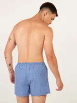 Bóxer de algodón blanco con estampado de flores pequeñas color celeste, con cintura elástica y logo de la marca en el centro.