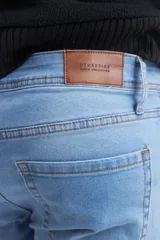 Pantalón de jean azul de corte slim, tiro alto y largo hasta el tobillo.