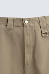 Pantalón chino de corte baggy fit, confeccionado en tejido de algodón. Presenta perneras amplias y holgadas, bolsillos frontales y traseros, con cierre de cremallera y botón.