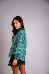 Camisa de manga larga con diseño abullonado, confeccionada en tela bordada con motivos florales. Presenta cierre frontal con botones y puños elásticos.