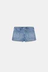 Short de denim azul claro con tiro bajo, bolsillos grandes en el delantero y cierre frontal con cremallera. Incluye una trabilla ancha con ojales y hebilla metálica.