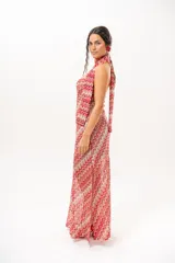 Vestido largo de crochet con escote strapless y lazo integrado para el cuello, con diseño de patrón en zigzag en tonos rojos, blancos y beige, y aberturas laterales en la falda.