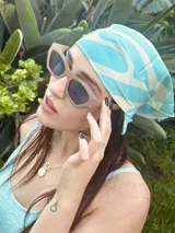 Pañuelo cuadrado de tela satinada celeste con estampado de ondas blancas.