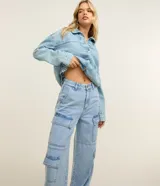 Pantalón estilo años 90 de tiro alto confeccionado en jean, con bolsillos cargo en los laterales y trabillas en la cintura.