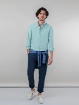 Camisa celeste de corte clásico, con cuello abotonado, manga larga y logo bordado en el pecho.