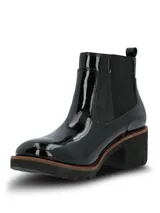 Botas Chelsea Hush Puppies de caña corta, confeccionadas en material sintético con acabado charol brillante. Presentan elásticos laterales para un calce sencillo, suela robusta de goma con plataforma y taco ancho.