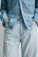 Jeans flare fit confeccionados en denim de algodón de tejido rígido, color celeste claro. Presentan diseño de cintura efecto revés, cinco bolsillos, tiro medio y cierre frontal con cremallera y botón.