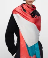 Pañuelo rectangular de poliéster reciclado con diseño estampado abstracto que combina tonos de rojo, turquesa, negro y blanco.