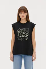 Musculosa color crudo con estampado frontal de paisaje montañoso y texto "EXPLORING Outlands", corte holgado y aberturas laterales en el ruedo.