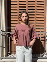 Blusa color chocolate de diseño holgado, con cuello redondo, frunce frontal y mangas abullonadas con puños ajustados.