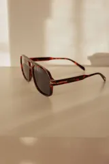 Lentes de sol con armazón de estilo aviador cuadrado en tono carey y cristales degradados en color ámbar.