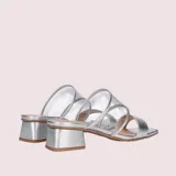 Sandalias plateadas con dos tiras transparentes de vinilo y taco cuadrado bajo.