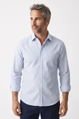 Camisa de manga larga con diseño de rayas verticales celestes y blancas, cuello clásico y cierre frontal de botones.
