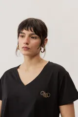 Remera de manga corta color negro, de corte clásico y escote en V, con sutil detalle bordado en el pecho.