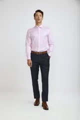 Camisa de vestir blanca de corte clásico, con cuello rígido, cierre frontal de botones y mangas largas con puños abotonados.