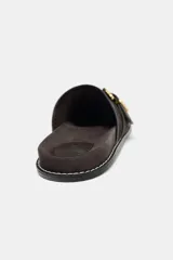 Zueco plano color marrón con hebilla metálica dorada.