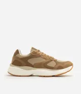 Championes deportivos para hombre de color marrón, con diseño de paneles en malla y material sintético tipo gamuza. Poseen entresuela gruesa de color blanco y suela de goma con tracción.