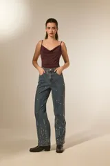 Pantalón jean azul de corte recto y calce alto, con bolsillos y detalles de strass.