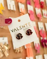 Par de caravanas con forma de rosa color borgoña con borde dorado.