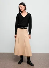Jersey de punto fino color negro, con cuello en pico y solapa tipo polo, de manga larga y diseño recto.