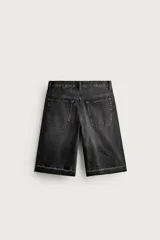 Bermuda de denim de algodón con efecto lavado desgastado en tonos marrones y azules. Tiene tiro medio, diseño de cinco bolsillos, pierna recta de corte holgado y bajo con acabado irregular. Cuenta con cierre frontal de cremallera y botón metálico.