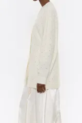 Cárdigan negro de corte recto en mezcla de mohair, con escote pico pronunciado, manga larga, cierre frontal con botonadura y piedras por toda la prenda.