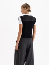 Chaleco negro de largo a la cintura con frente bordado en lentejuelas formando figuras de cerezas. Presenta espalda y sisas tejidas, mangas de organza plisada y cierre frontal con botones grabados.