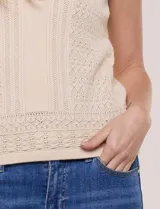 Musculosa tejida de marca Elie Tahari, color blanco, con cuello con solapa y escote V pronunciado, confeccionada en tejido de punto calado con patrón geométrico.