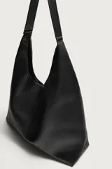 Bolso shopper negro de hombro, de diseño liso y estructura suave, con compartimento principal y asa integrada.