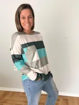 Remera de manga larga en tejido liviano con diseño de rayas anchas en tonos fucsia, gris y crudo. Corte recto y cómodo con bolsillo delantero.