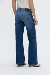 Jean de denim azul con calce recto y pierna amplia de caída relajada, tiro bajo y bolsillos clásicos.
