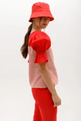 Blusa de mangas cortas abullonadas color verde claro, con escote cuadrado y cuerpo a rayas horizontales grises y blancas.