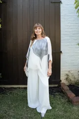 Pantalón tipo palazzo de gasa plisada en color blanco off-white. Presenta un diseño de pierna ancha, caída fluida y forro interno.