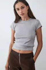 Pantalón de tiro medio con acabado efecto ante, diseño de pierna recta, con bolsillos laterales y traseros, y cierre frontal con cremallera metálica.