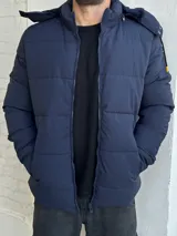 Campera puffer azul marino con capucha y cierre frontal con cremallera.