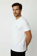 Remera de manga corta y cuello redondo, color blanco, de corte holgado, con estampa pequeña de un velero en el pecho.