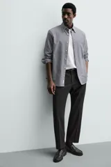 Pantalón de vestir regular fit color negro, confeccionado en tejido con mezcla de lana y elasticidad. Cuenta con cintura elástica, bolsillos frontales, bolsillos traseros de vivo con botón, y cierre frontal con cremallera y botón.