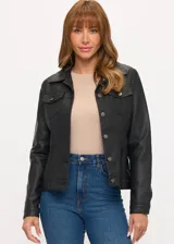 Campera de cuero sintético en color negro, con diseño tipo trucker, cuello clásico, cierre frontal con botones metálicos y bolsillos con solapa en el pecho.