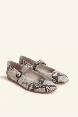 Zapatos tipo Mary Jane con estampado de piel de serpiente, capellada de cuero vacuno, forro y plantilla de cuero vacuno, y suela de cuero. Tienen un taco bajo de 1 cm y una correa con hebilla negra sobre el empeine.