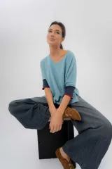 Pantalón jean de tiro medio bajo y pierna amplia, con diseño de cortes modernos y bolsillos funcionales delanteros y traseros.