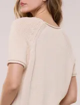 Buzo tejido de punto jersey de algodón color beige, de diseño relajado, escote redondo amplio y mangas cortas raglán.